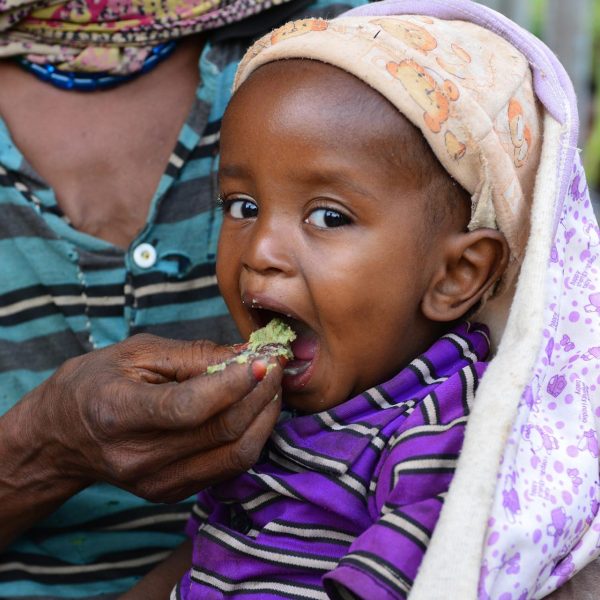 Una bebé come galletas energéticas de UNICEF para poder recuperarse de la desnutrición. Estas galletas son muy útiles ante situaciones de emergencia.